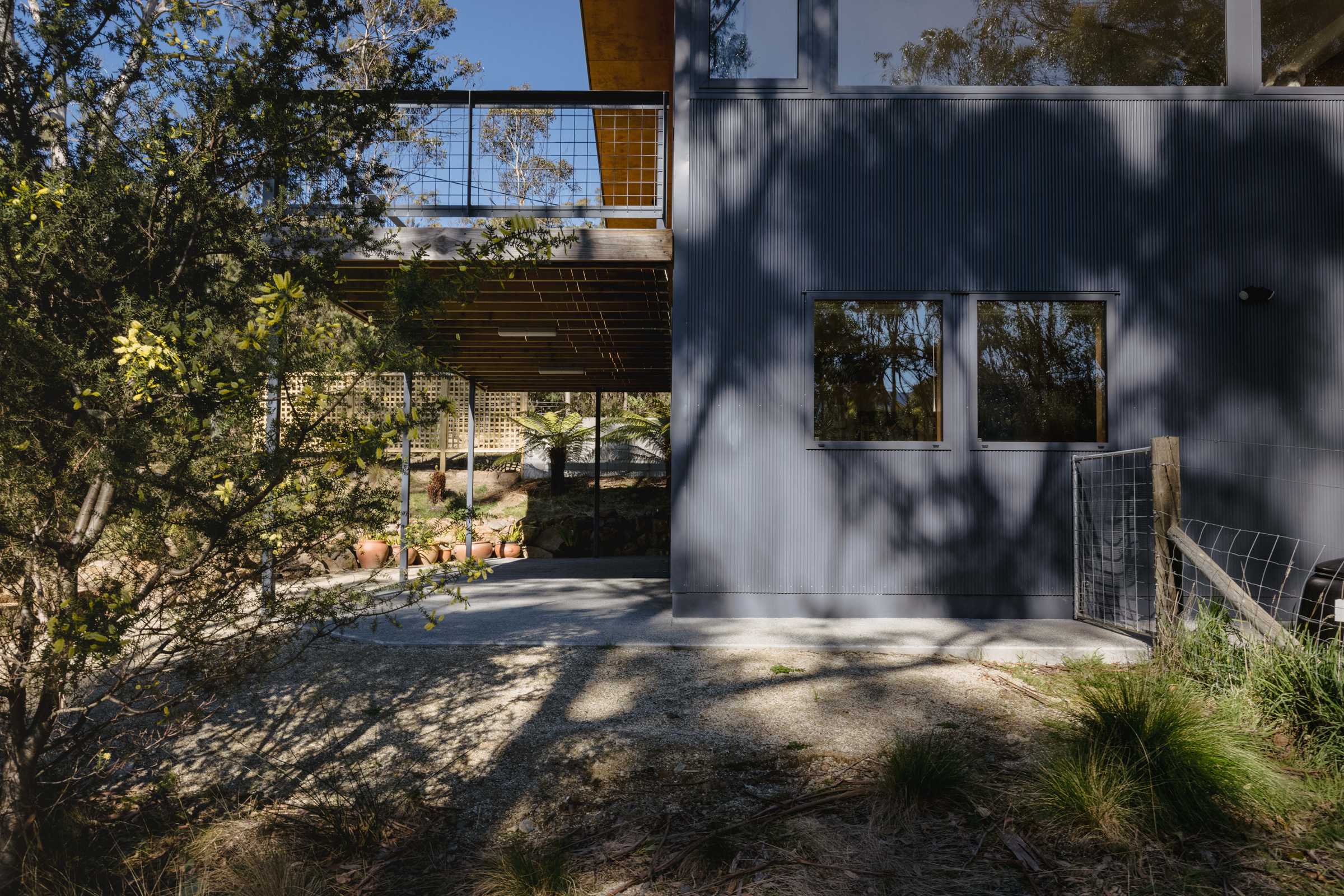 Mt Nelson home renovation features custom mini orb, double glazed and thermally broken windows and a concrete path exposed aggregate. The renovation was to improve the amenity of the space under the house by building it in, creating two extra bedrooms and a usable under-house storage space. Credit: Jordan Davis.