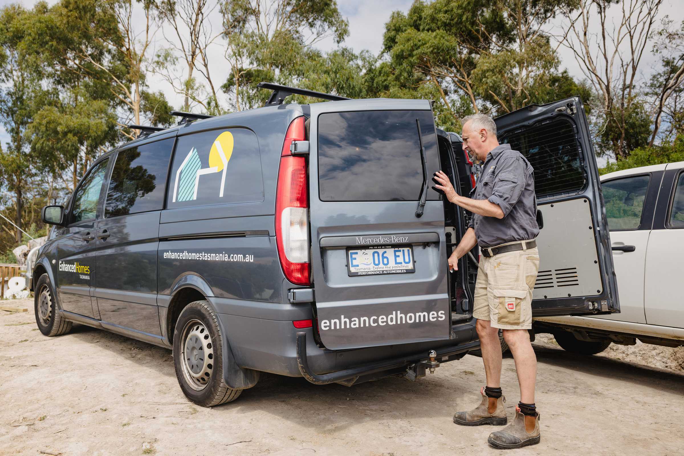 Experienced builder getting equipment from an Enhanced Construction Tasmania branded van. Credit: Jordan Davis.