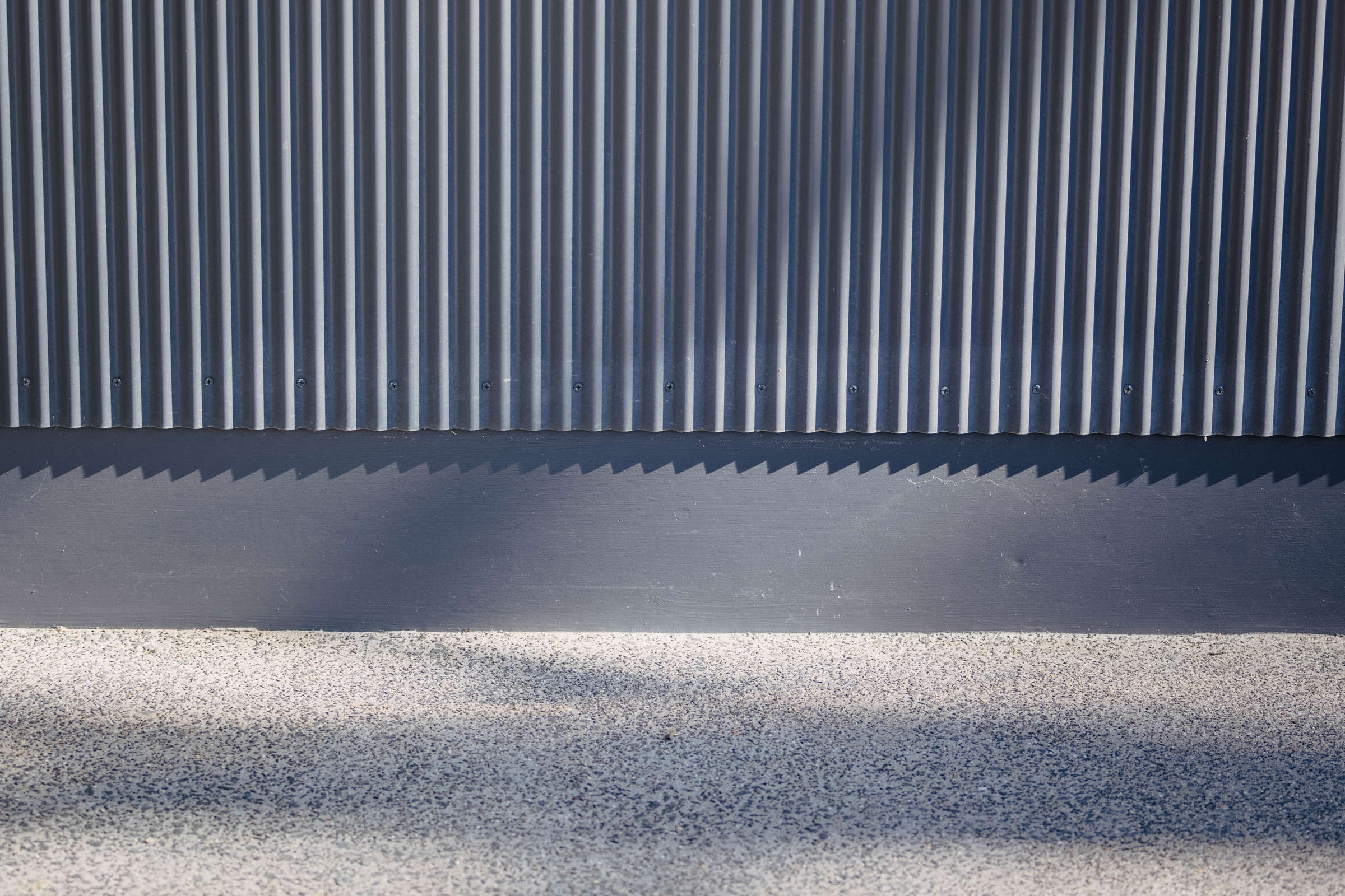 Wall cladding in custom mini orb and a concrete path with exposed aggregate. Credit: Jordan Davis.