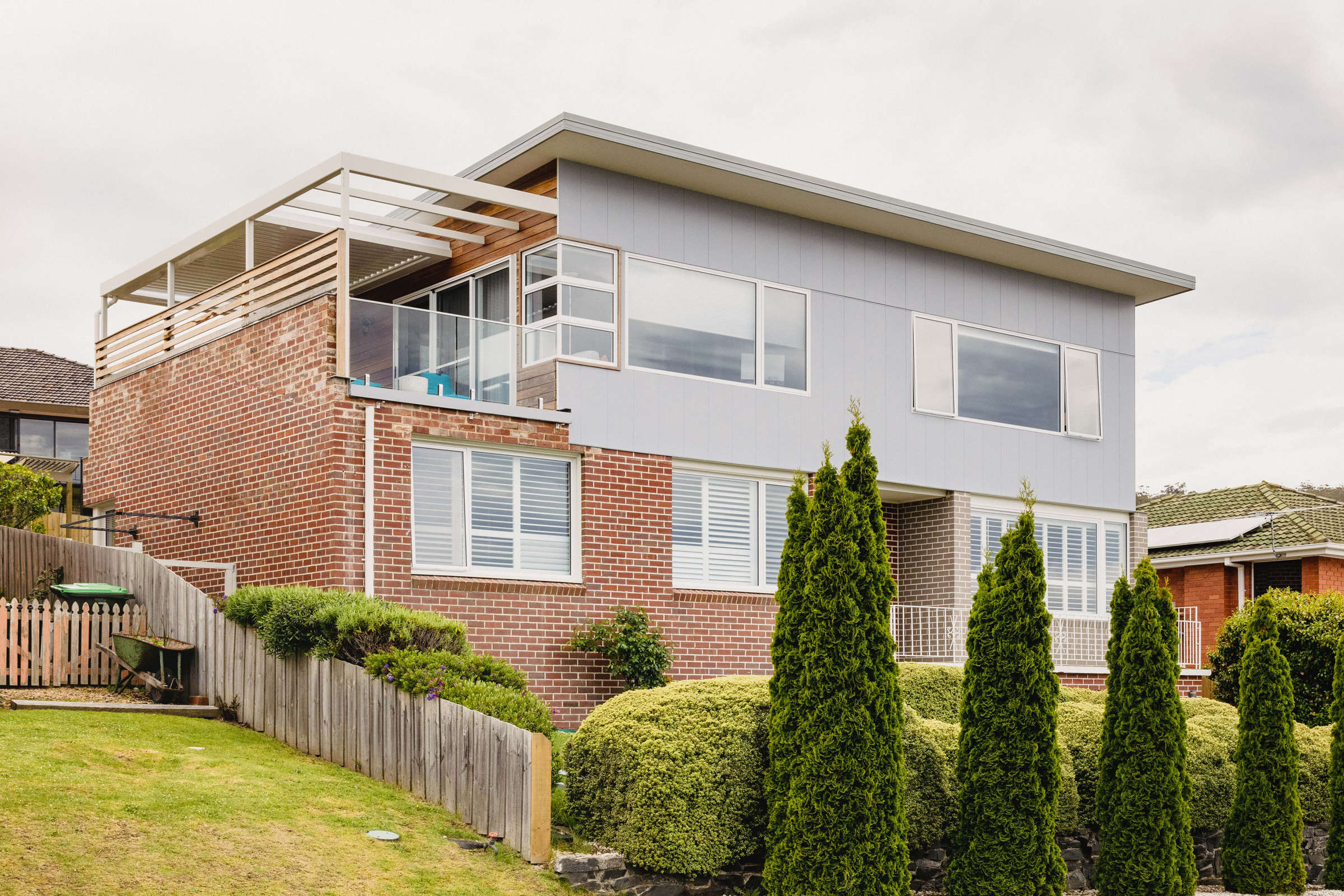 This Howrah home renovation added a second storey to a double brick 1960s house as a lifestyle renovation. It features steel framework over an external deck, motorised louvre system, sauna, ensuite bathroom, glass balustrade and a beautiful view. Credit: Jordan Davis.