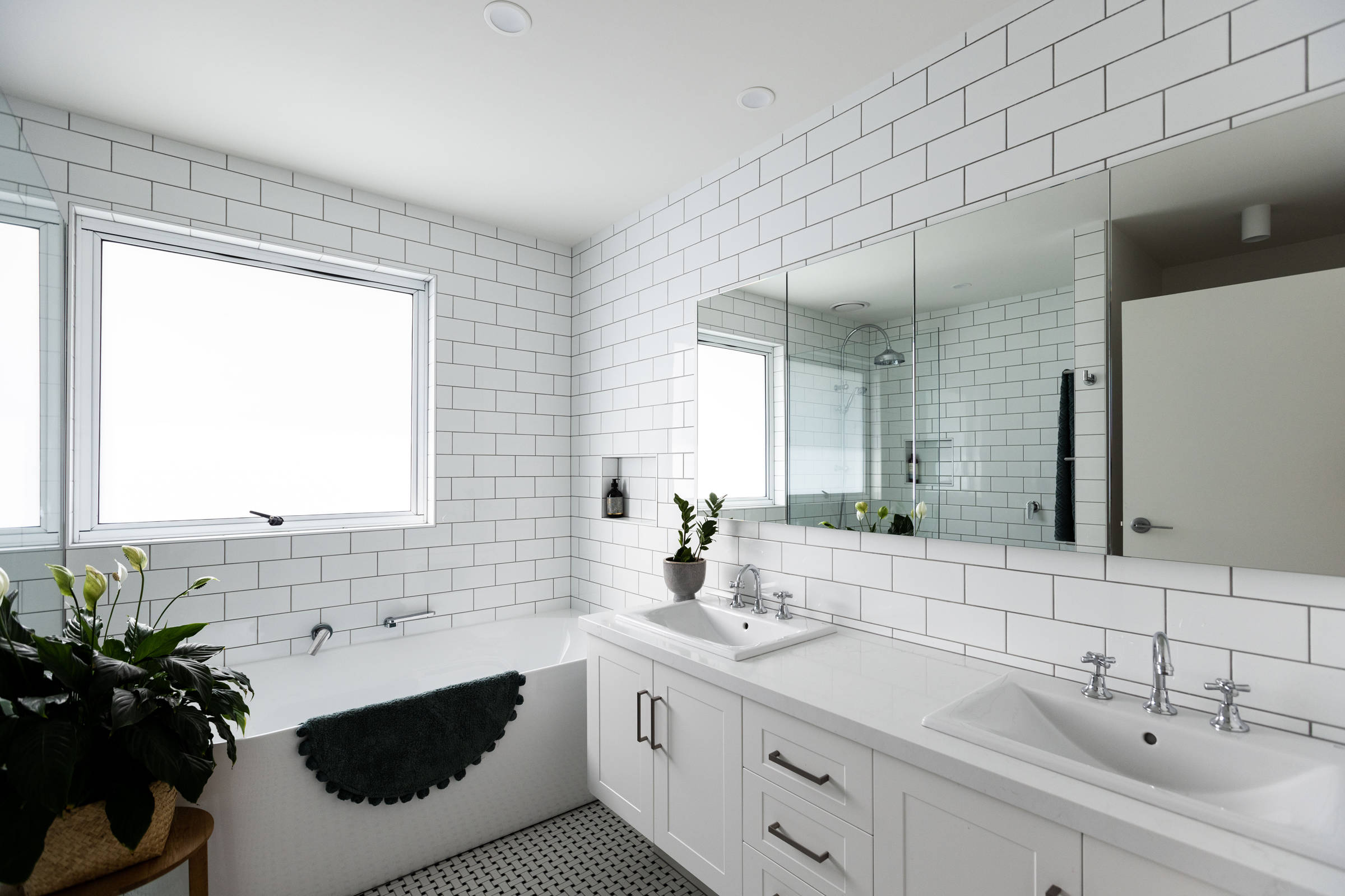 Bathroom renovation featuring white subway tiles and an Italian tile floor with a light, bright contemporary finish. Credit: Jordan Davis.