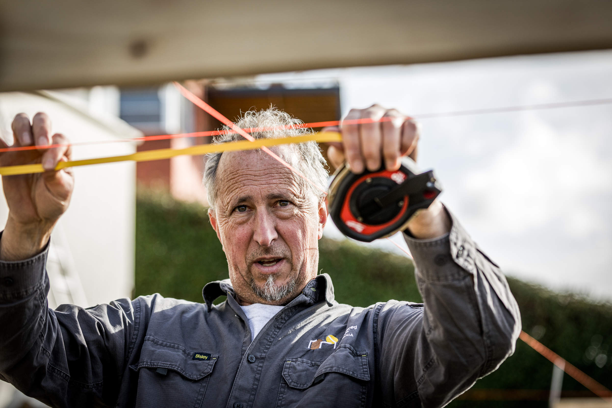 Site foreman checking for accuracy and ensuring there is attention to detail, through careful measurement, using stringlines as part of a client’s front deck construction. Credit: Jordan Davis.