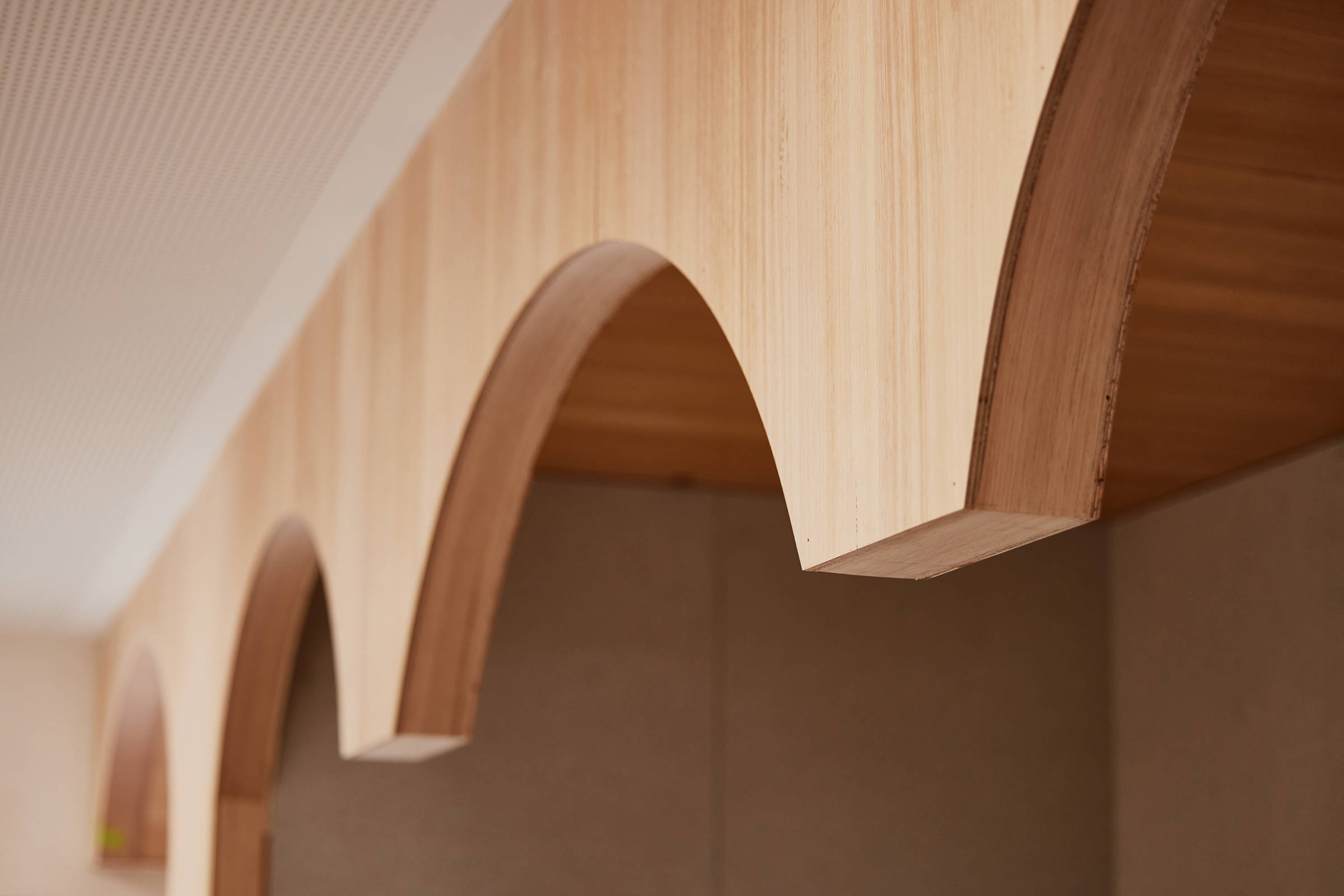 Closeup image of small curved plywood timber arches that detail a book reading nook in a library. Credit: Samuel Shelley.