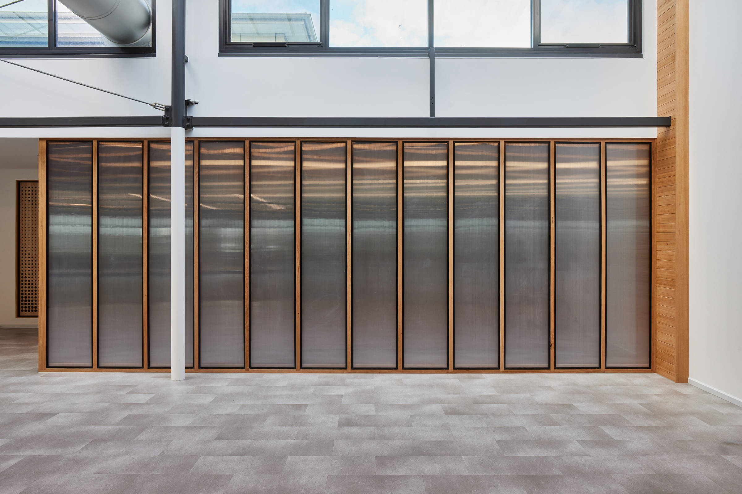 An internal decorative light wall of symmetrical panels, surrounded by black aluminium trim and Tasmanian oak. Credit: Samuel Shelley.