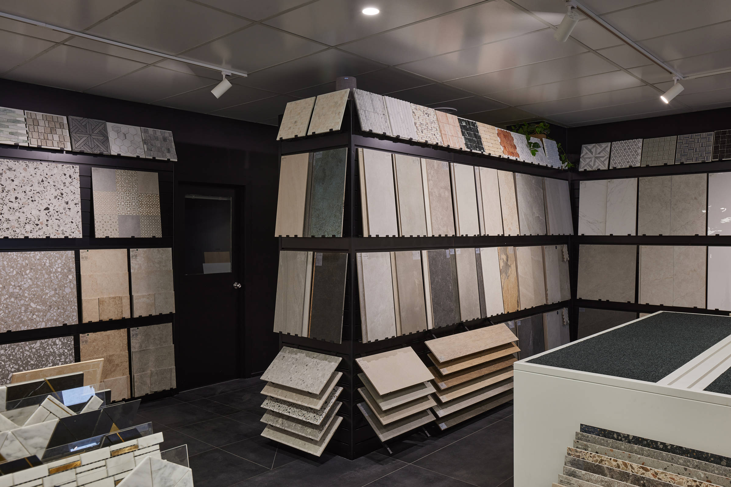 Floor-to-ceiling four-level tile display unit in the showroom. Decorative 30×30cm tiles on the top level, levels two and three are 30×60cm tiles, and the tiles on the lower level are of mixed sizes. Credit: Samuel Shelley.